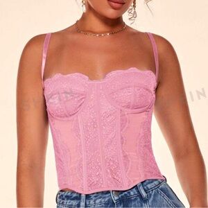 The pink lace corset top has a delicate and intricate floral pattern throughout.